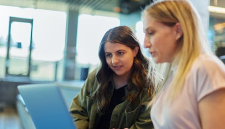 Two software engineers looking at a laptop.